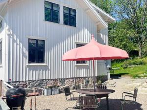 a table with a pink umbrella in front of a building at Charming Villa Retreat-By Traum in Varekil