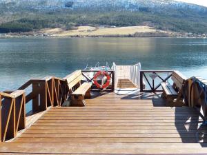 eine Anlegestelle mit Bänken und ein Boot auf dem Wasser in der Unterkunft 6 person holiday home in EIDSVÅG-By Traum in Eidsvåg
