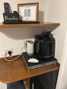 a coffee maker sitting on a shelf with a coffee pot at Somewhere Nice & Cozy in Little Clacton +10 photos