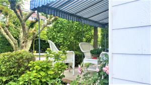 Un patio con dos sillas y un dosel azul. en Rulons Cape May Diamond, 1St, en Cape May
