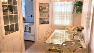 Una cocina con una mesa de cristal y sillas. en Rulons Cape May Diamond, 1St, en Cape May