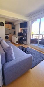 a living room with a blue couch and a kitchen at LOLA in Puy-Saint-Vincent +13 photos