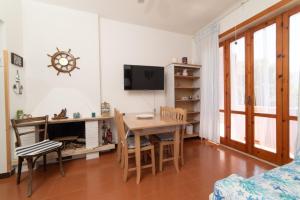 a living room with a table and a desk and a tv at La Maison de Annabella in Palinuro +21 photos