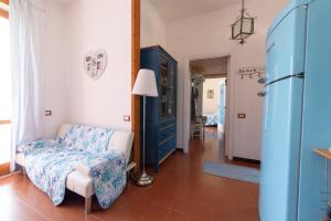 a living room with a couch and a chair and a lamp at La Maison de Annabella in Palinuro