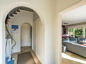 een boog leidt naar een woonkamer met een blauwe bank bij Oostduinkerke Forestside Villa in Oostduinkerke +32 foto's