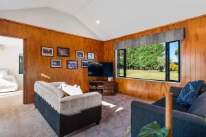 a living room with a couch and a tv at Relax Countryside in Turangi