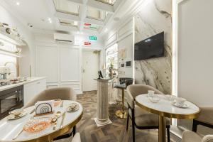 ein Wohnzimmer mit 2 Tischen und Stühlen sowie eine Küche in der Unterkunft La Bella Trevi in Rom