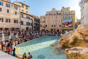 Eine Menschenmenge, die um einen Brunnen steht. in der Unterkunft La Bella Trevi in Rom
