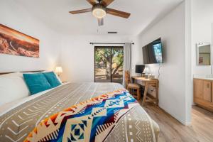 Schlafzimmer mit einem Bett, einem Deckenventilator und einem Schreibtisch in der Unterkunft Private Sedona Home with Pool, Golf, Pickleball in Sedona + 25 Fotos