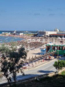 a beach with umbrellas and people on the beach at Ultracentral Mangalia seaside exclusive in Mangalia