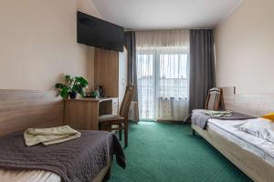 a hotel room with two beds and a desk at Willa Sole in Busko-Zdrój