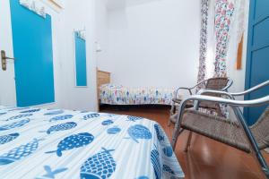 a bedroom with a bed with a blue and white comforter at La Maison de Annabella in Palinuro