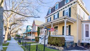 une maison arborant un drapeau américain devant elle dans l'établissement Lillys Butterscotch Cottage-5 Bdrm Wbonus Loft!!, à Cape May