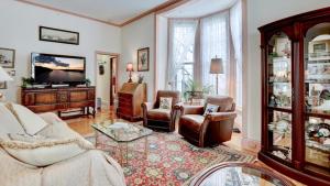 un salon avec un canapé, des chaises et une télévision dans l'établissement Lillys Butterscotch Cottage-5 Bdrm Wbonus Loft!!, à Cape May