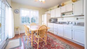 une cuisine avec une table, des chaises et un évier dans l'établissement Lillys Butterscotch Cottage-5 Bdrm Wbonus Loft!!, à Cape May