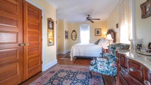 une pièce avec une chambre avec un lit et une table dans l'établissement Lillys Butterscotch Cottage-5 Bdrm Wbonus Loft!!, à Cape May