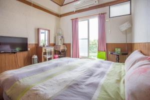 a bedroom with a large bed and a television at Chenyuan B&B in Ji'an