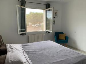 a bedroom with a bed and a window and a chair at L'Escapade Jaune - Jacuzzi, Wi-Fi, tout équipée in Carcassonne