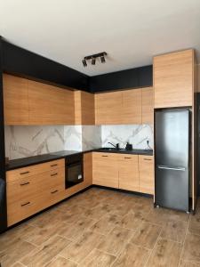 a large kitchen with wooden cabinets and a refrigerator at Magic Jar in Toruń