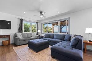 Una sala de estar con un sofá azul y sillas. en 4BR Kona Home with Ocean Views, en Kailua-Kona