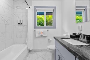 Un baño blanco con bañera, inodoro y lavabo. en 4BR Kona Home with Ocean Views, en Kailua-Kona 26 fotos más