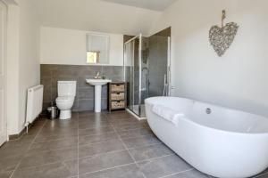 ein Badezimmer mit Badewanne, Toilette und Waschbecken in der Unterkunft Oak Cottage and Hot Tub, Loch Tay in Lawers + 24 Fotos