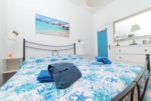 a bedroom with a bed with blue sheets at La Maison de Annabella in Palinuro