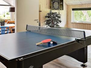 a ping pong table with a racket and ball on it at 5 star holiday home in Stege in Stege