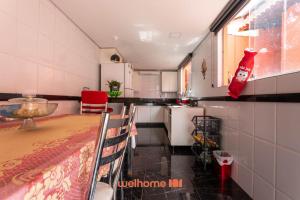 una piccola cucina con tavolo, tavolo e sedie di Casa em BH com Localização Incrível e Conforto a Belo Horizonte
