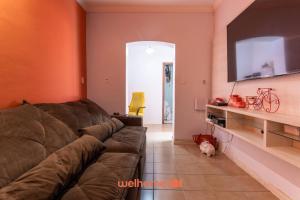 un soggiorno con divano e TV a schermo piatto di Casa em BH com Localização Incrível e Conforto a Belo Horizonte Altre 14 foto