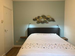 a bedroom with a bed with areath on the wall at Beautiful holiday home Zeeroos in Zeeland in Dishoek
