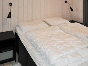 a large white bed with two pillows on it at 4 star holiday home in Øyer in Øyer
