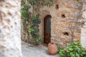 a stone building with a wooden door and a vase at Kladomita in Mestá