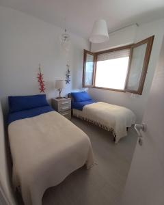 a bedroom with two beds and a window at La Casa del Sole in Follonica