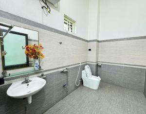 a bathroom with a sink and a toilet and a mirror at Villa Ngân Hà in Kon Rung (1)