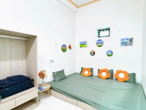 a bedroom with a green bed with stuffed animals on it at Villa Ngân Hà in Kon Rung (1)