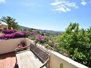 a wooden bench sitting on a balcony with flowers at Coastal Villa Near Beaches in Moraira