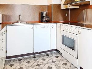 a kitchen with white cabinets and a stove top oven at 6 person holiday home in Hvide Sande in Hvide Sande +30 photos