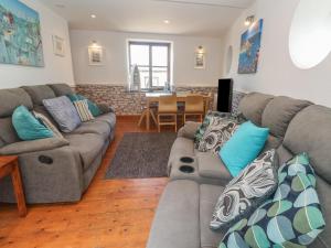 ペンザンスにあるMill House Barnのソファとテーブルのあるリビングルーム