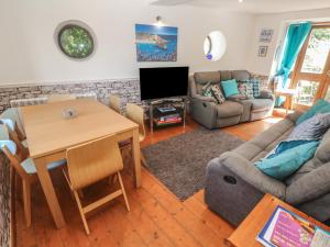 a living room with a table and a couch at Mill House Barn in Penzance