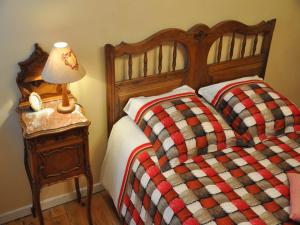 a bedroom with a bed and a lamp on a night stand at Chalet in Raon-l'Étape near Lake in Raon-lʼÉtape