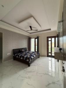 a bedroom with a bed in a room with marble floors at Fully furnished 2BHK At Sahastradhara road in Dehradun