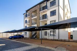 a building with black umbrellas in front of it at AlimamaSpaces Panos Whisken in Midrand