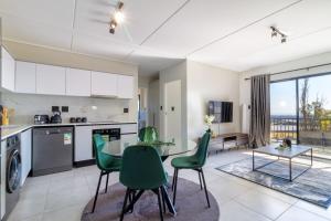 a kitchen and living room with a table and chairs at AlimamaSpaces Panos Whisken in Midrand
