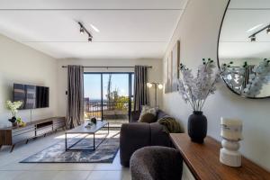a living room with a couch and a table at AlimamaSpaces Panos Whisken in Midrand