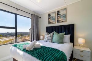 a bedroom with a bed with a large window at AlimamaSpaces Panos Whisken in Midrand +45 photos