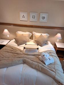 a large bed with a laptop on top of it at Conforto Flat Hotel Vila Olimpia in São Paulo