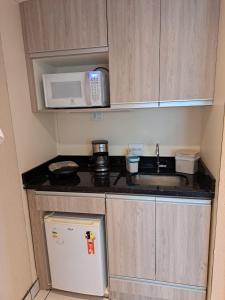 a small kitchen with a sink and a microwave at Conforto Flat Hotel Vila Olimpia in São Paulo +15 photos
