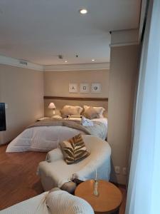 a bedroom with two beds and a table at Conforto Flat Hotel Vila Olimpia in São Paulo +15 photos