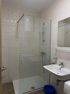a bathroom with a glass shower and a sink at Forte Mare Apartment in Podgorica